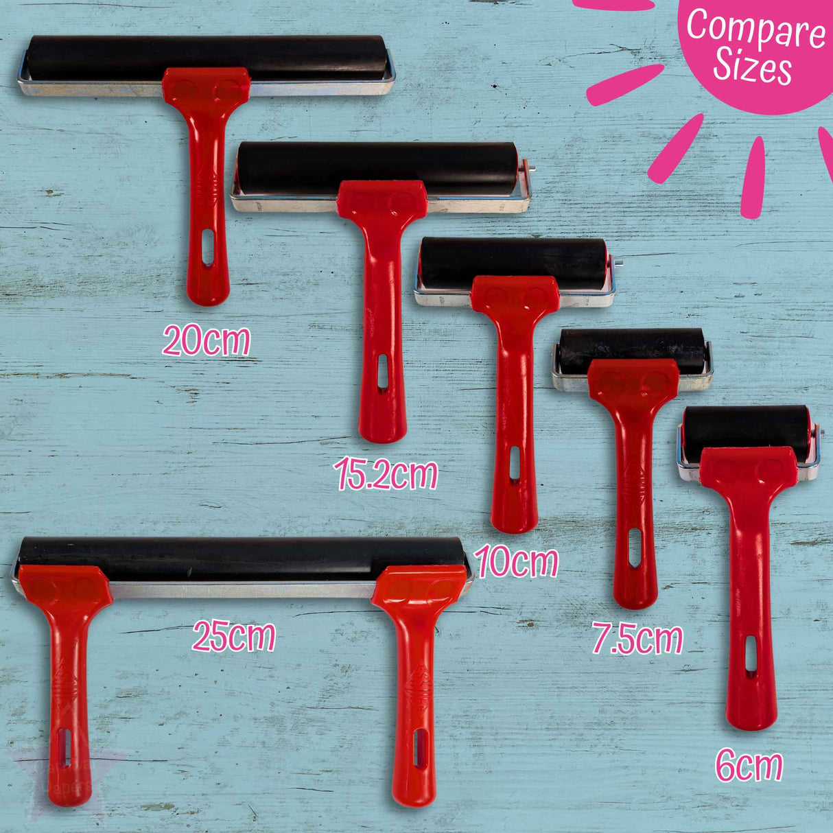 Set of red brayer rollers with varying sizes on a blue wooden surface