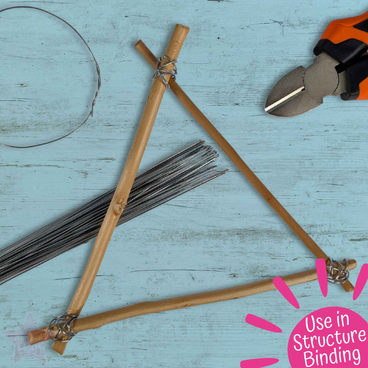 A DIY structure binding kit laid out on a light blue wooden surface, featuring natural bamboo sticks, metal wire, and orange-handled shears. A pink graphic overlay in the bottom right corner reads 'Use in Structure Binding'.