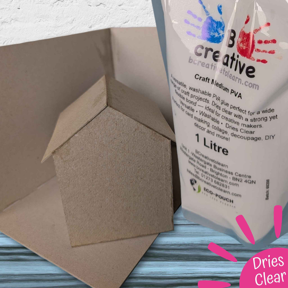 Bag of B Creative craft medium PVA next to a cardboard house model